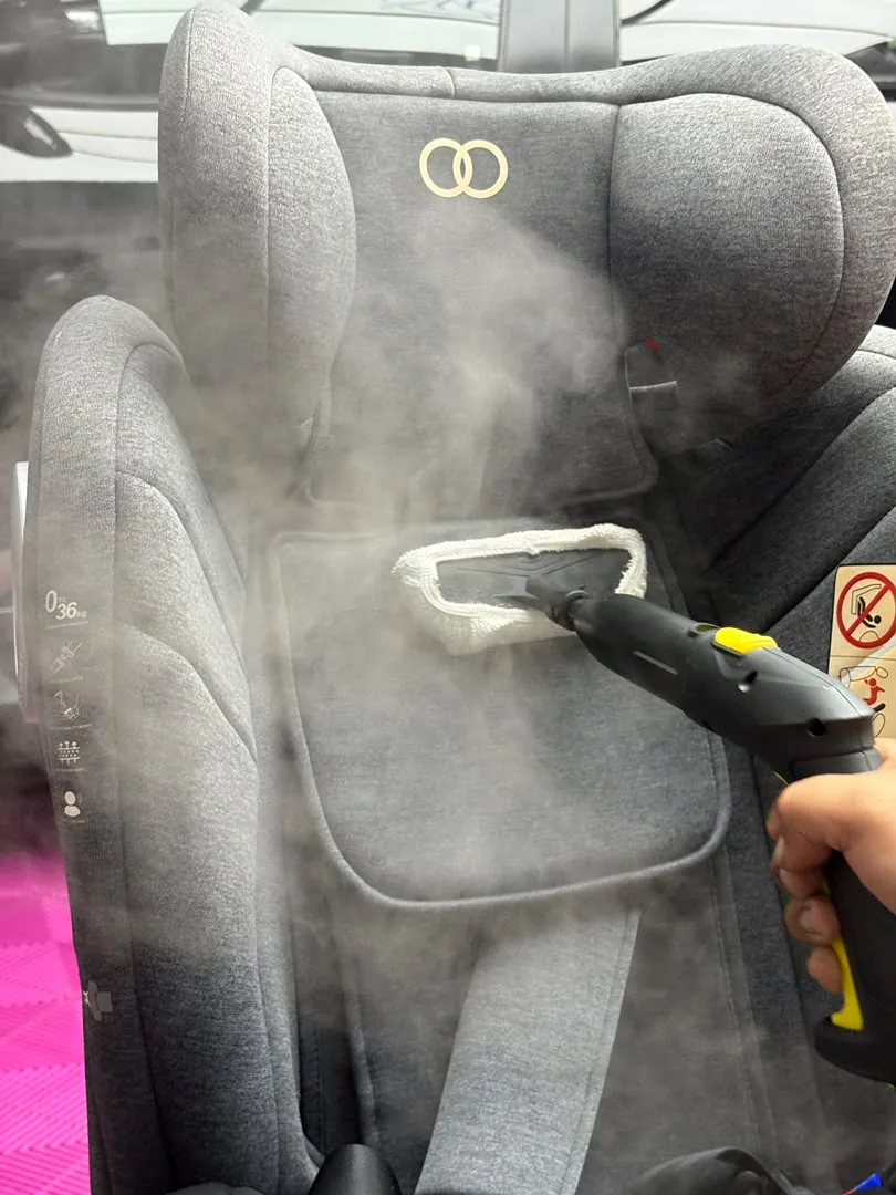 Steam-cleaning a child car seat at the 9NERS studio