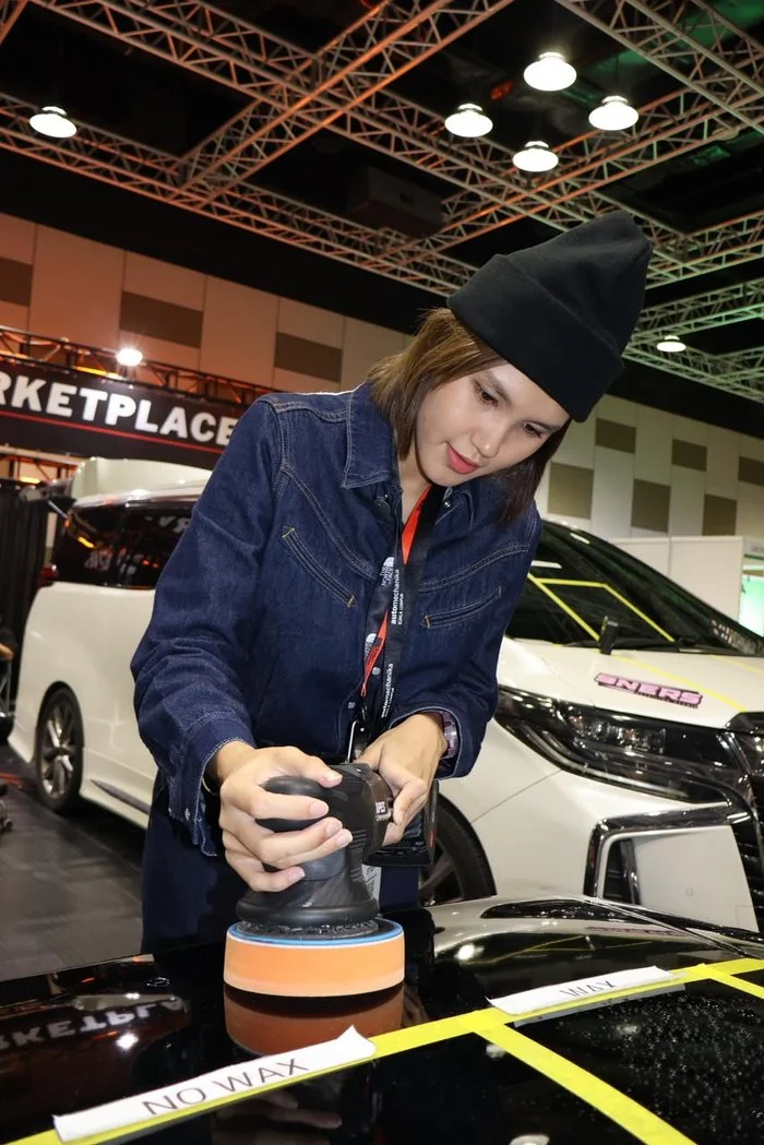 Nina Yahya machine-polishing a car bonnet at an expo
